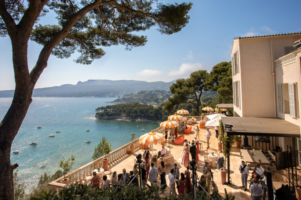 Terrasse du Domaine de Canaille à Cassis avec parasol rayé orange et vue sur la Méditerranée lors d’un mariage de destination dans le Sud de la France.