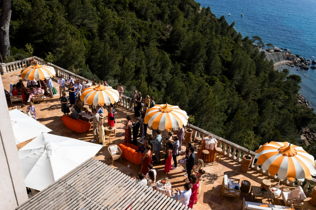 Terrasse du Domaine de Canaille à Cassis avec parasol rayé orange et vue sur la Méditerranée lors d’un mariage de destination dans le Sud de la France.